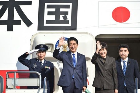 Thủ tướng Nhật Bản Shinzo Abe và phu nhân Akie vẫy tay chào mọi người trước khi lên máy bay tại sân bay Haneda ở Tokyo ngày 17-11.